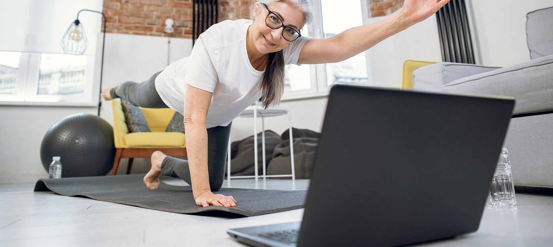 woman doing online physical therapy in fornt of notebook